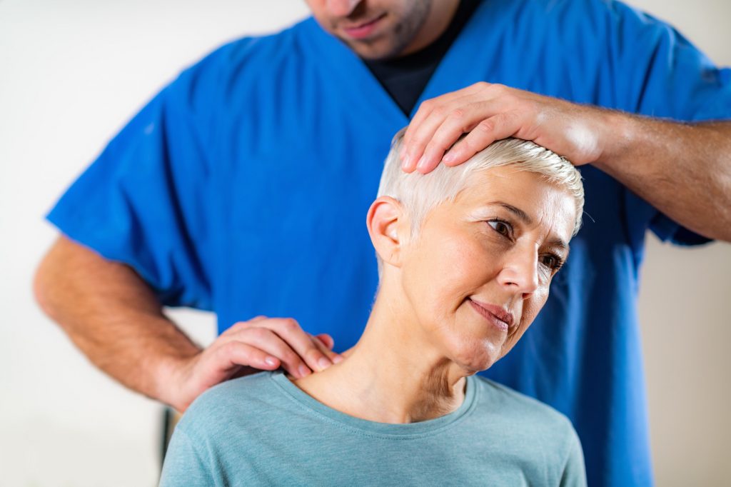 Physical Therapist Stretching Senior Woman’s Neck